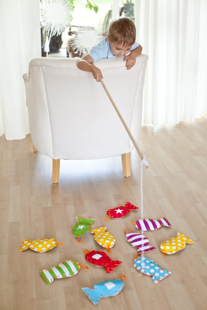 jouet de jeu de poisson fait maison de Design Dazzle - garçon jouant au jeu de poisson sur une chaise 