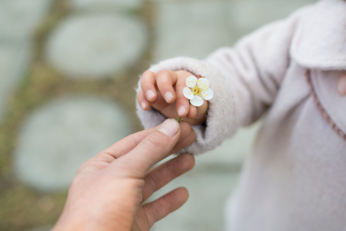 Motricité fine - enfant tenant une fleur en pince - Kids Activities Blog
