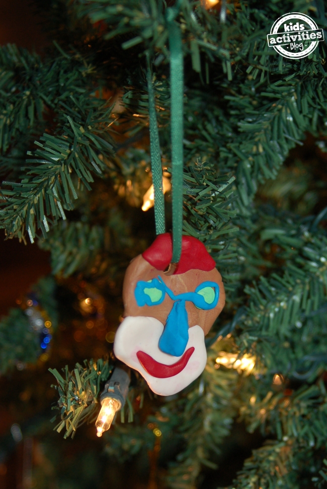Picasso a inspiré des ornements d'arbre de Noël avec des cheveux rouges, une bouche, un nez et des yeux bleus, avec des pupilles vertes et un ruban vert