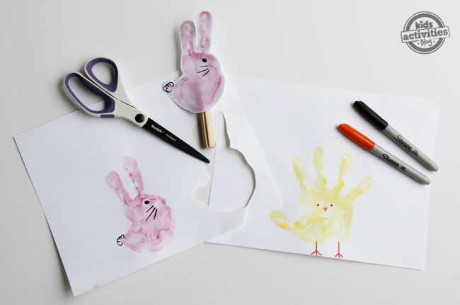 comment faire des marionnettes à empreinte de main - Étapes 4 et 5 - Lapins roses et poussins jaunes avec pattes, moustaches, becs, yeux et queues, avec un bâton de marionnette, des sharpies rouges et noirs et des ciseaux - blog d'activités pour enfants