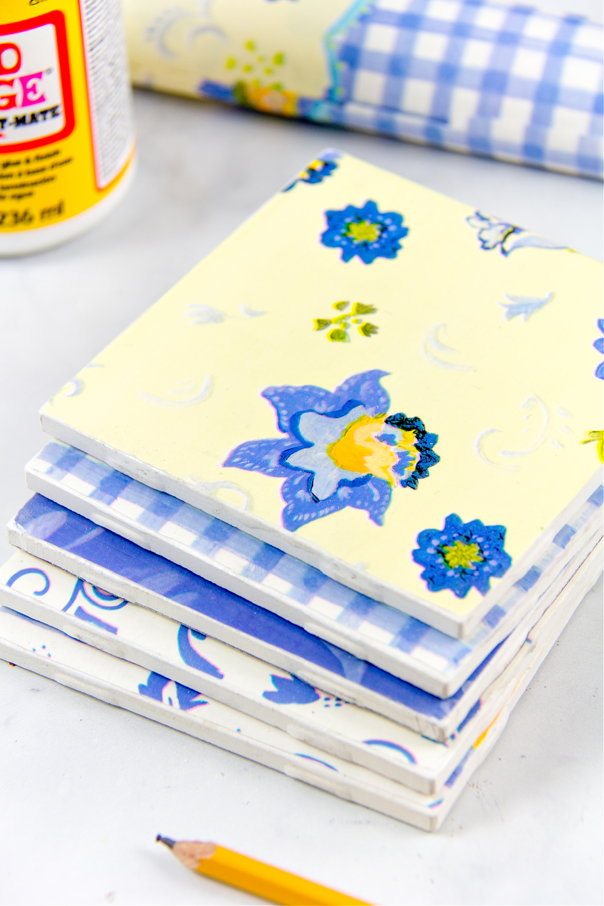 Une pile de sous-verres bleus, jaunes et blancs faits de tuiles et de papier cadeau