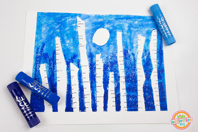 Winter Forest Preschool Art - Blog d'activités pour enfants - bâtons de peinture bleu clair, bleu, bleu foncé avec une lune blanche et des bouleaux sur fond blanc