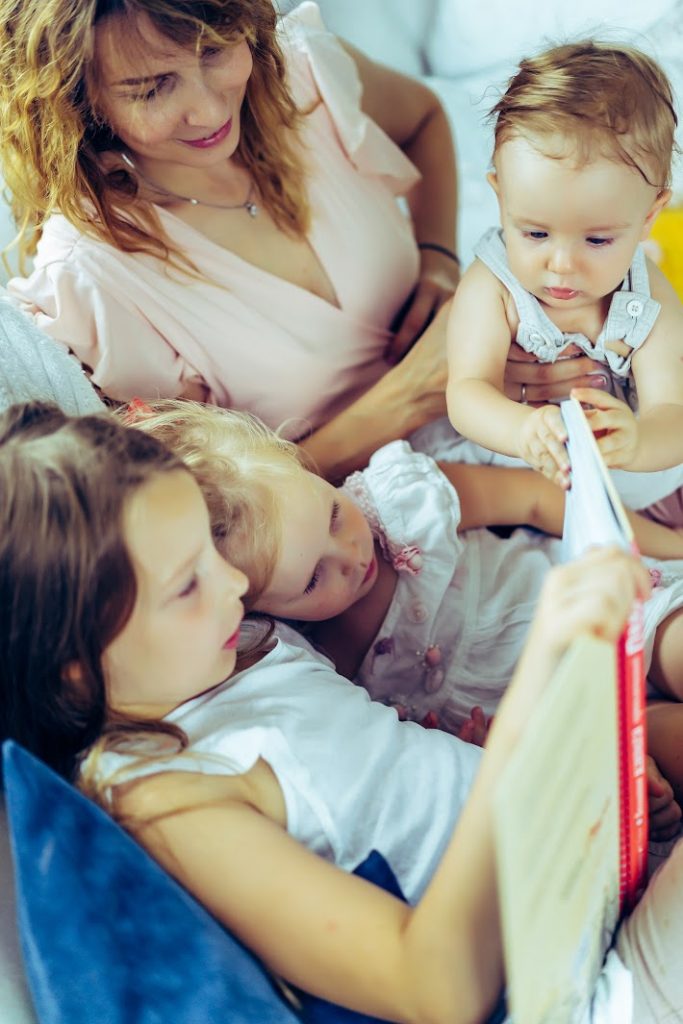 L'heure du conte - Blog d'activités pour enfants - famille allongée dans son lit en lisant un livre