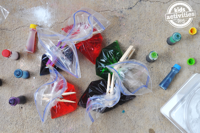 Expérience scientifique Exploding Baggies - étape 2 - Tournez les sacs au-dessus du liquide et fixez-les avec une épingle à linge.