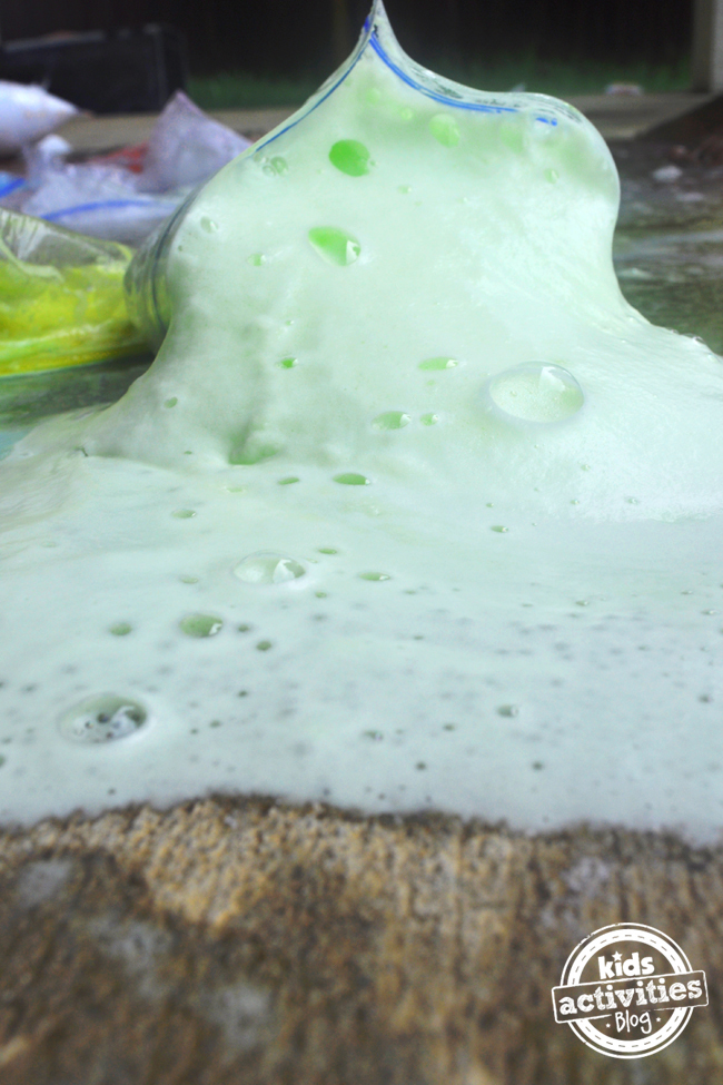 Exploding Baggies - Sac posé sur du béton suintant de mousse verte - Blog d'activités pour enfants