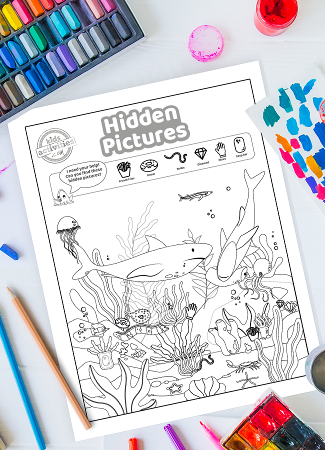 Trouvez les images cachées dans ce requin imprimable Puzzles pour enfants - feuille de travail de requin avec images cachées entourée de peinture, de crayons de couleur et d'autres fournitures d'art