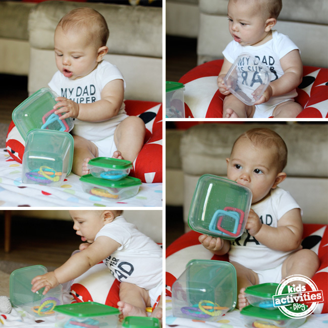 Bébé assis avec des contenants Tupperware transparents et verts contenant des jouets et qui les ouvre, les secoue et les mâche