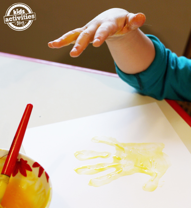 artisanat d'empreinte de main avec de la peinture comestible étape 2 empreinte de main sur un morceau de papier blanc - blog d'activités pour enfants