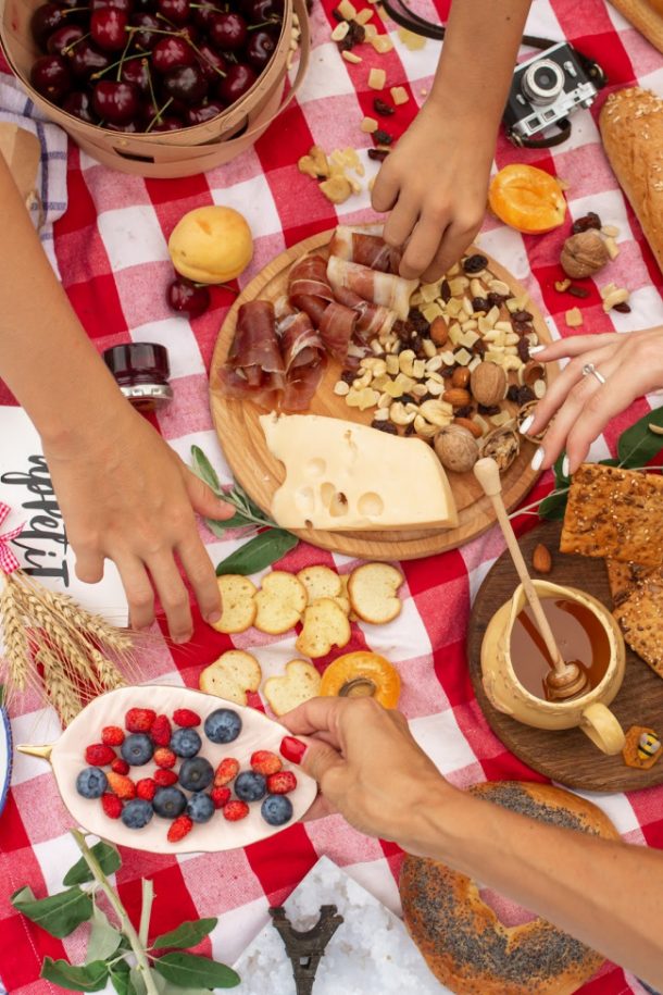 Date de pique-nique en famille - noix, fromage, pain, baies, miel, viande, sur une couverture à carreaux rouges et blancs - Saint Valentin pour la famille - blog d'activités pour enfants