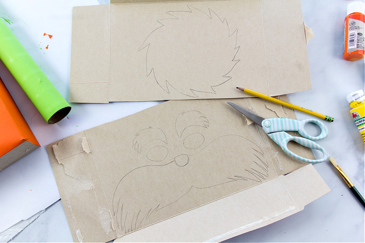 ÉTAPE 3 - Les traits du visage de Lorax sont esquissés à l'intérieur d'une boîte de céréales pour un projet d'artisanat pour les enfants.