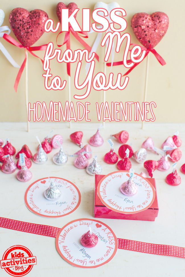 Texte : Un baiser de moi à toi Saint-Valentin maison avec des imprimables et des baisers Hershey et des cœurs scintillants rouges et blancs sur une table blanche - blog d'activités pour enfants