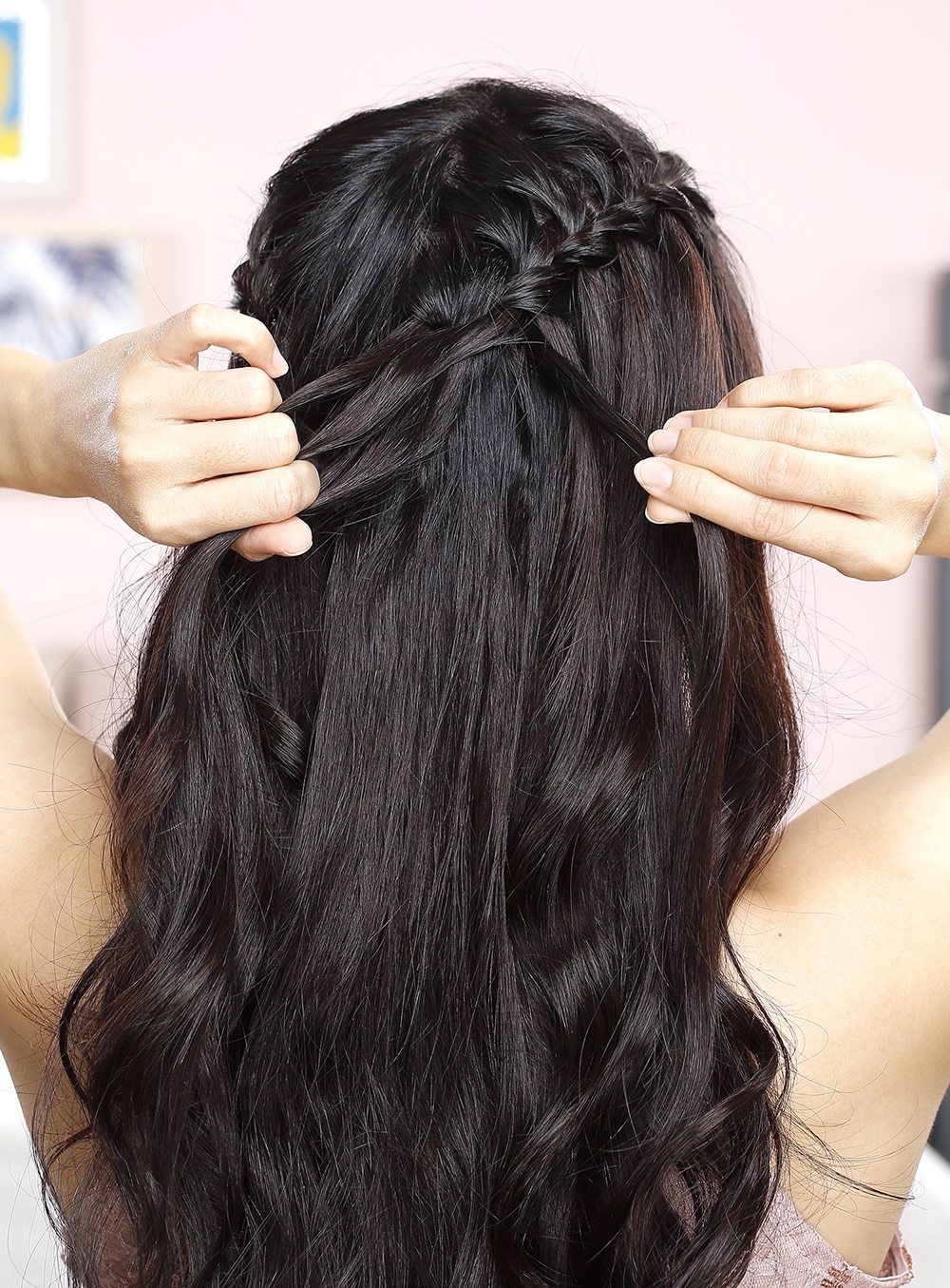 Femme se peignant les cheveux avec une tresse cascade et des vagues