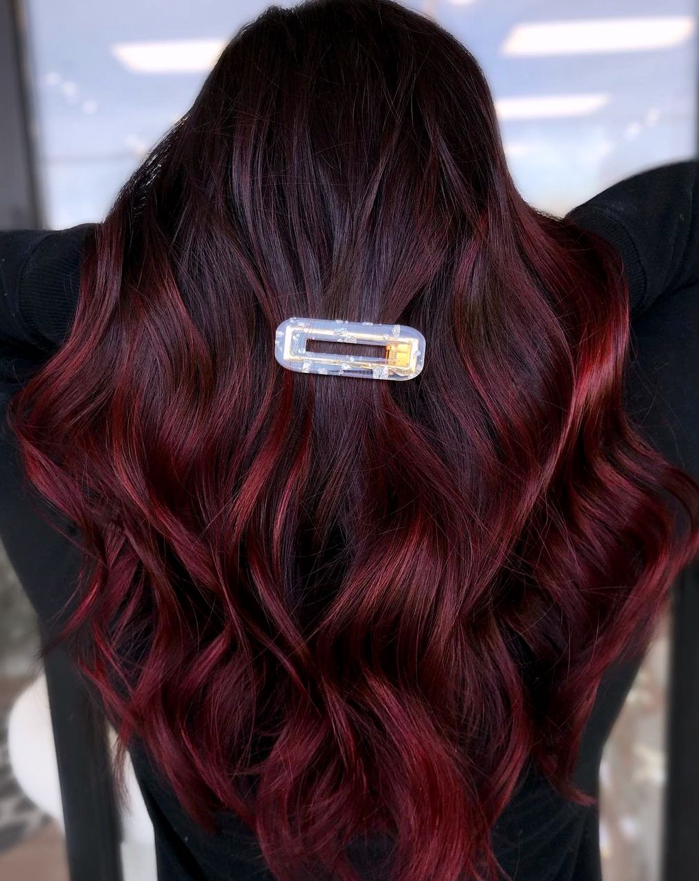 Femme avec un colorant cerise au chocolat dans de longs cheveux ondulés