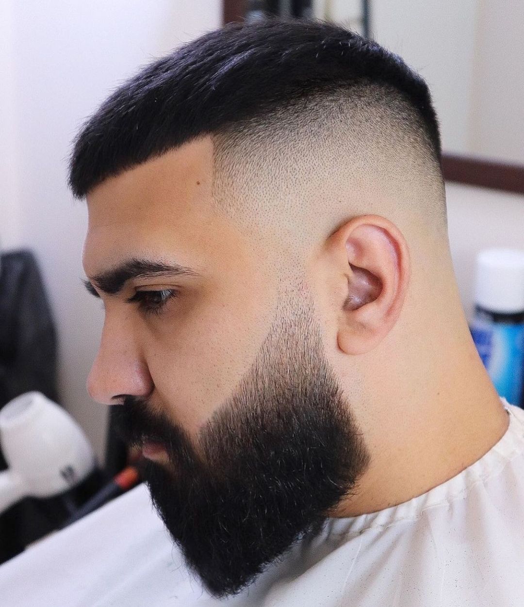 Homme avec une coupe déconnectée et une barbe soulignée