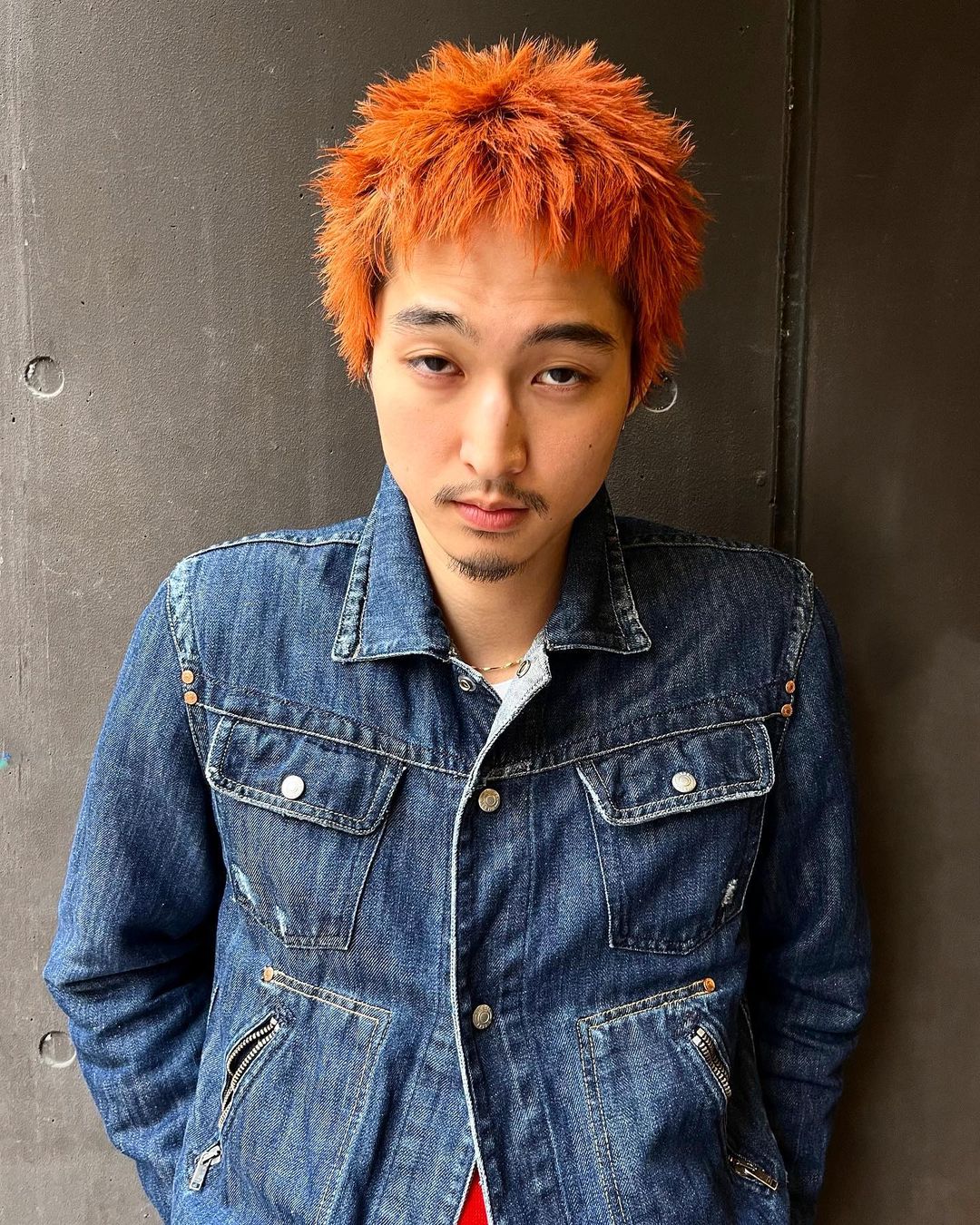 Homme avec coupe de cheveux anime avec teinte orange et pointes