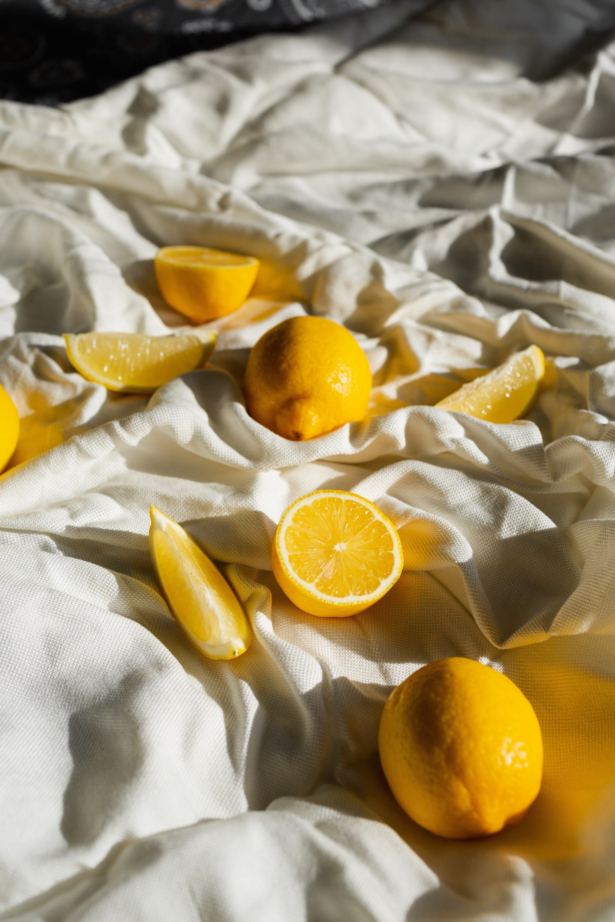 Citron jaune entier et coupé en deux sur un tissu blanc