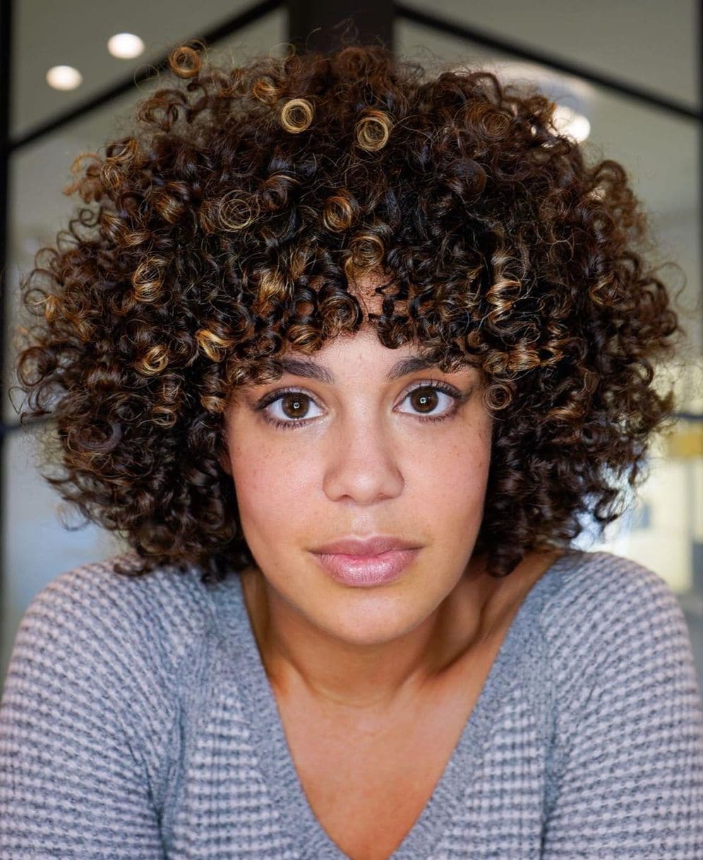 Femme au visage long avec une coupe de cheveux bouclés en couches rondes