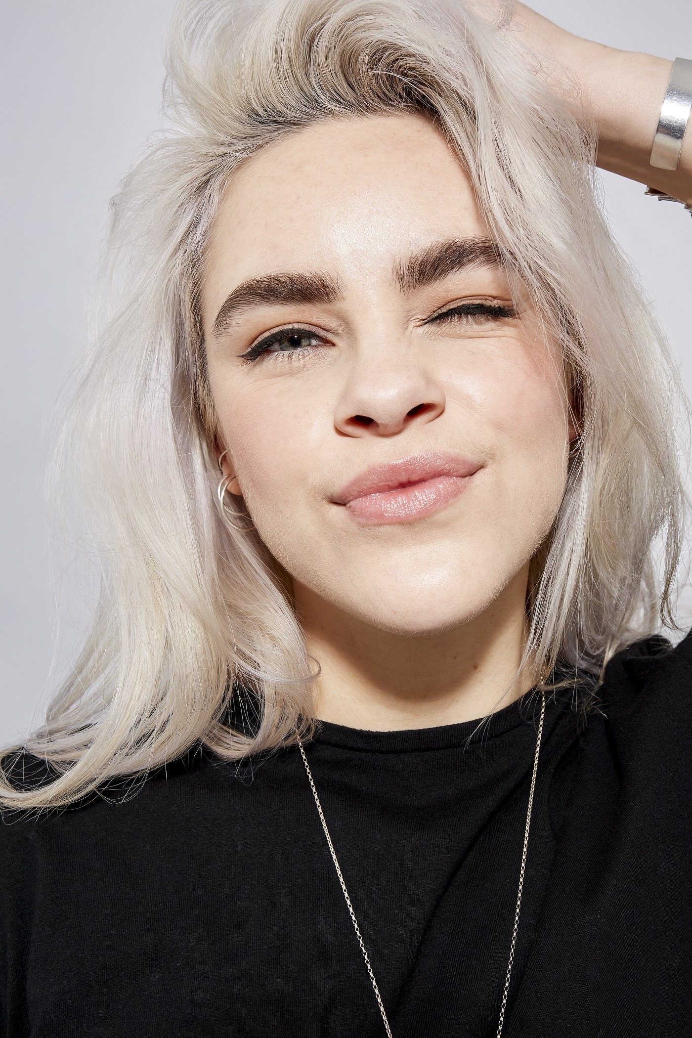 Femme blonde platine touchant sa tête