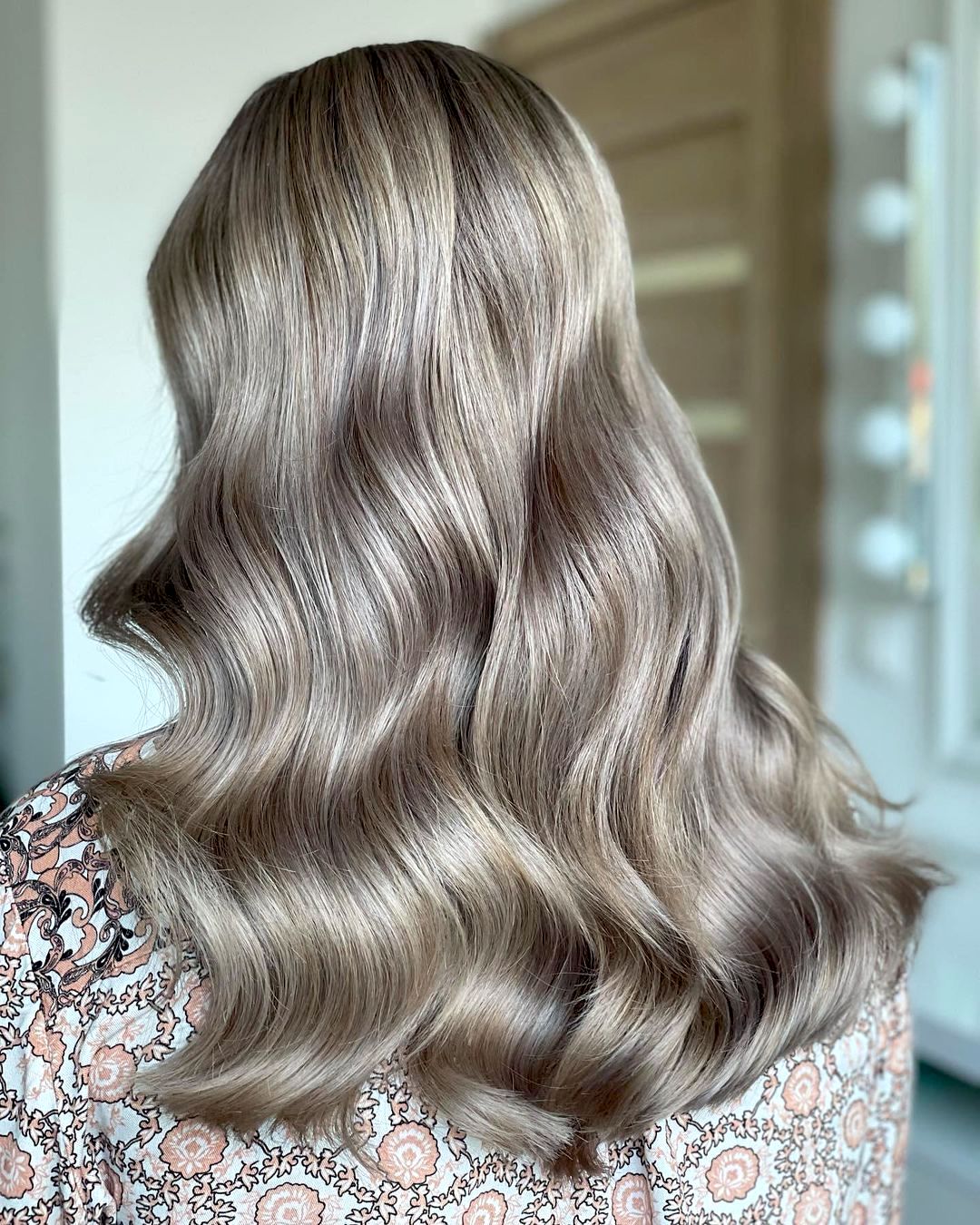 Femme aux cheveux moyens utilisant un shampooing tonifiant noir pour cheveux gris