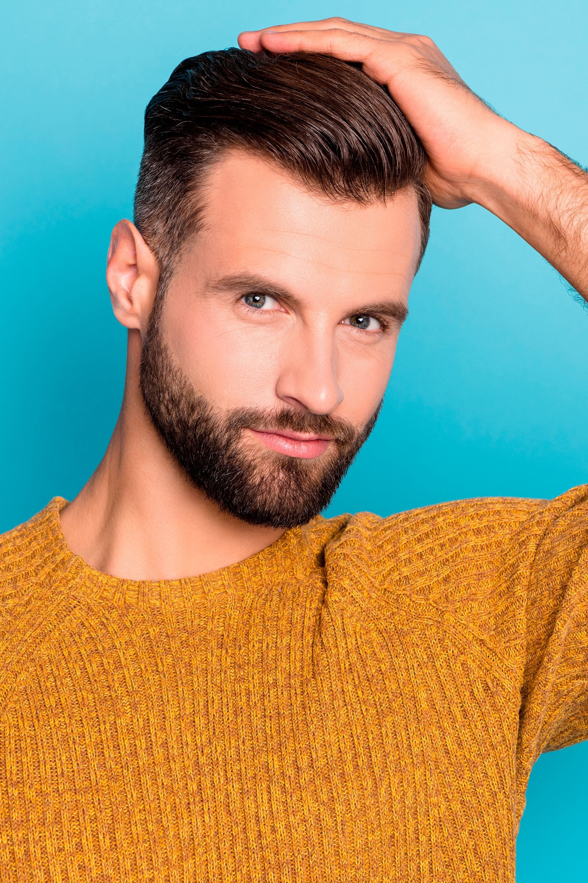 Homme aux cheveux bruns avec pompadour et barbe essayant différents shampooings pour la perte de cheveux due à la casse