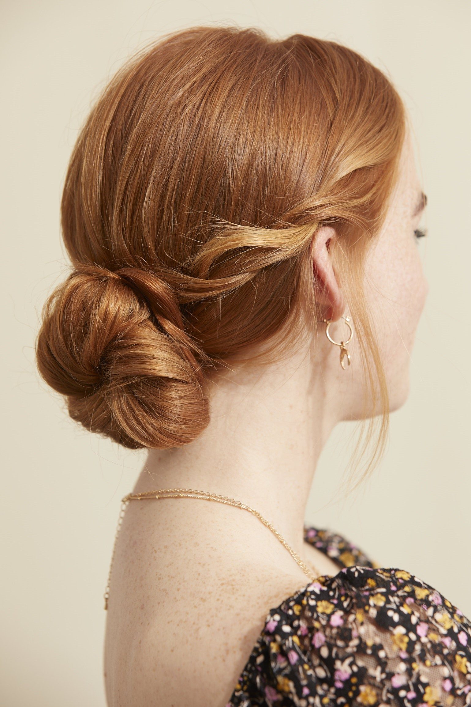 Femme avec un simple chignon bas et des mèches bouclées devant