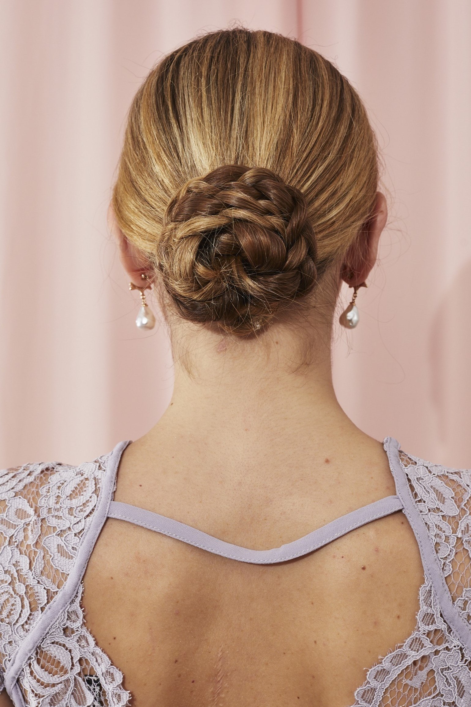 Femme avec des infirmières tressées en chignon bas