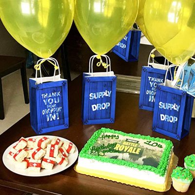 Gâteau Fortnite et sacs de fête Fortnite avec des ballons jaunes attachés dessus