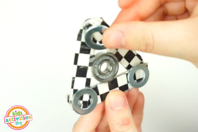 Ajouter du poids à l'artisanat Fidget Spinner - rondelles collées à chaque coin avec les doigts en les plaçant correctement