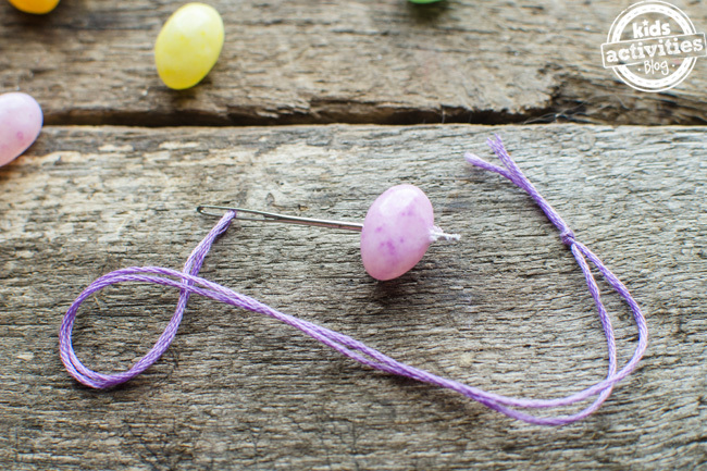 Étape 2 - artisanat de bracelet de jelly bean - enfilez le jelly bean sur l'aiguille et la ficelle