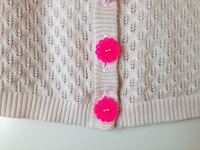 Fabriquez des boutons avec des perles perler et utilisez-les sur votre chemise ou votre pull - vu ici, de gros boutons roses en perles perler cousus sur un cardigan pull blanc de Maker Mama