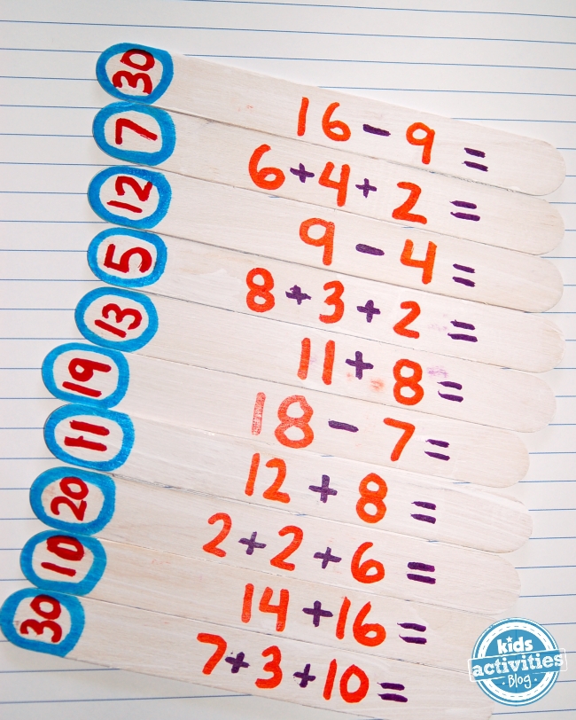 bricolage jeu de cartes flash de bâton de popsicle - bâtons de popsicle avec de la peinture rouge, bleue, violette et orange dessus avec addition et soustraction de problèmes mathématiques sur un bloc-notes - blog d'activités pour enfants