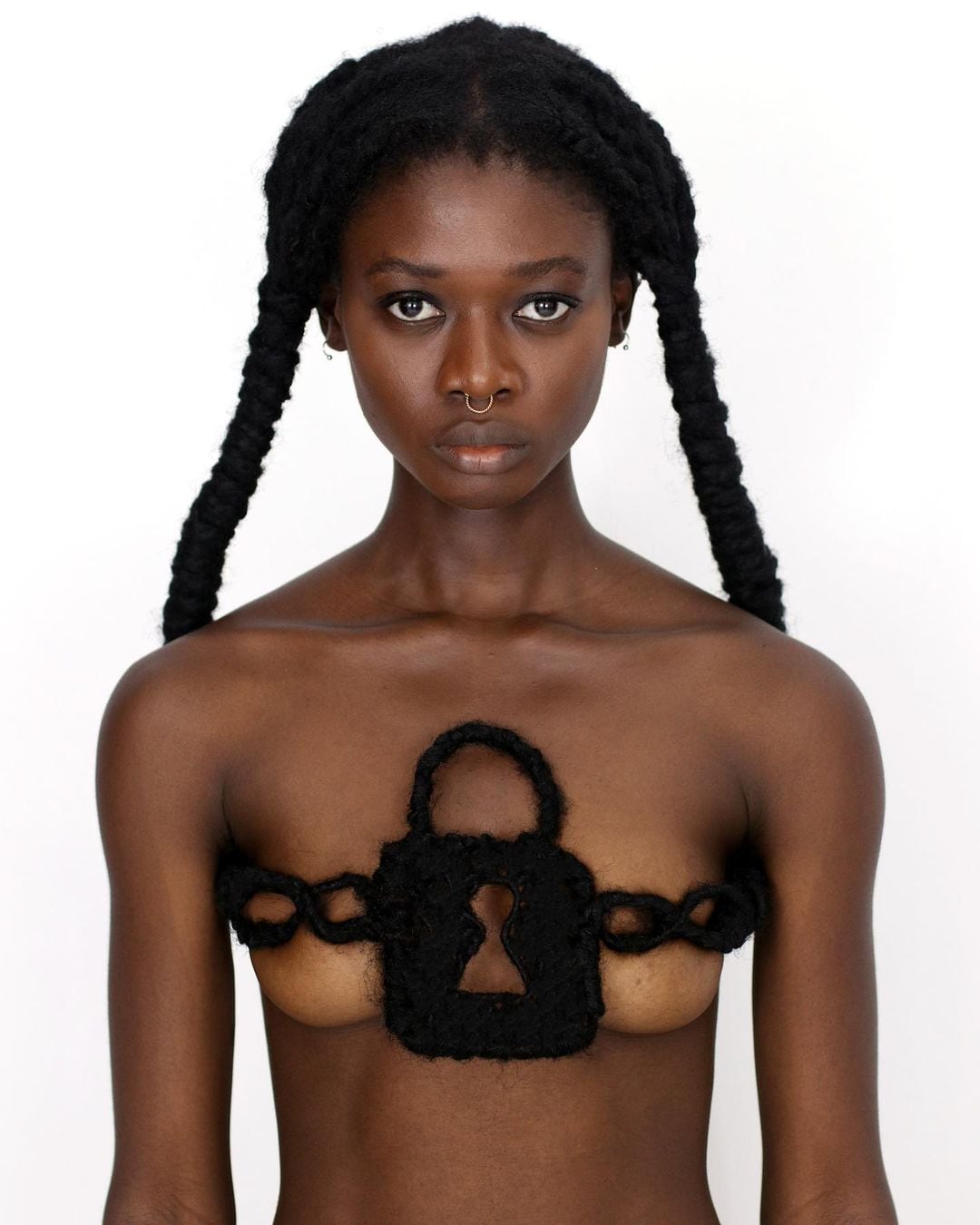 Laetita Ky modélise une sculpture de cheveux contre le repassage des seins
