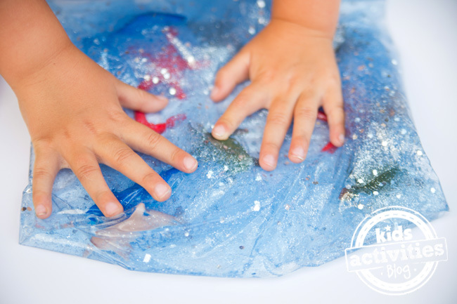 Fini Ocean Sensory Bag DIY avec les mains de l'enfant sur le sac sensoriel