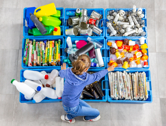 Centre de recyclage avec une fille triant les matières recyclables - Kids Activities Blog