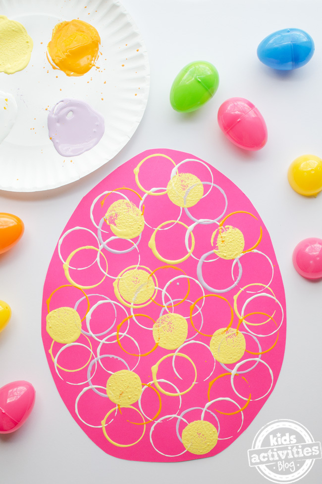 artisanat d'oeufs de Pâques préscolaire - activité pour Pâques préscolaire - oeuvre d'oeuf de Pâques finie sur une grande forme d'oeuf rose avec des couleurs de peinture jaune et argent - Blog d'activités pour enfants