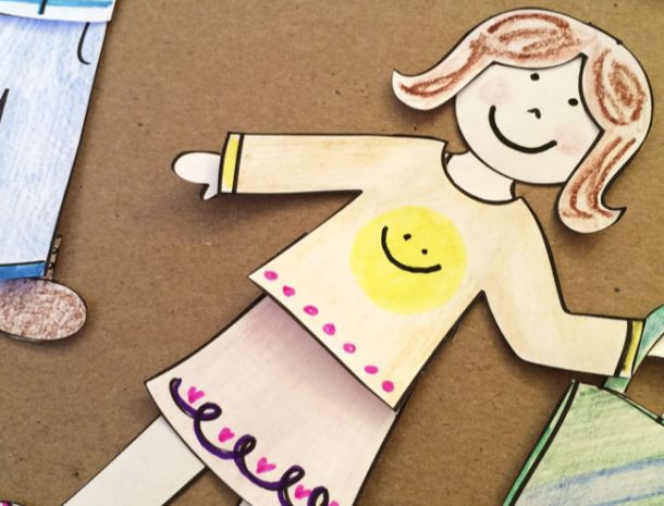 Écran de jeux gratuits comme jouer avec des poupées en papier - avec des cheveux bruns, des joues roses, un visage souriant. La chemise est orange avec un smiley jaune et des pois roses tandis que la jupe est rose avec des cœurs roses en bas et un sac à main vert et bleu avec un jean bleu et des bottes marron dans le coin de l'écran.