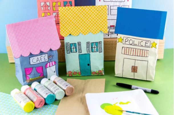 Étape 2 - Artisanat de sacs en papier Commencer à peindre vos maisons de sacs en papier et votre ville - utilisez des peintures acryliques (le jaune est indiqué sur la palette avec un pinceau) pour créer des endroits avec des sacs en papier comme des maisons, un hôpital, un poste de police, un café .