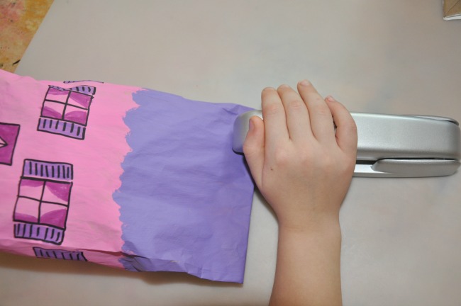 Étape 3 - Paper Bag House Craft Agrafez des sacs en papier pour faire semblant de ville - remplissez le sac avec du papier journal et agrafez les bâtiments fermés, celui-ci est une maison rose et violette.
