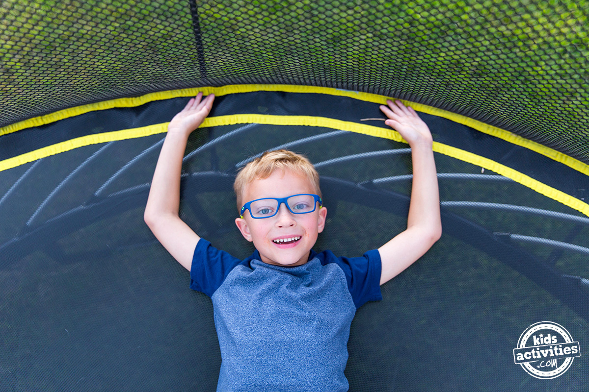 garçon allongé sur un trampoline sans ressort