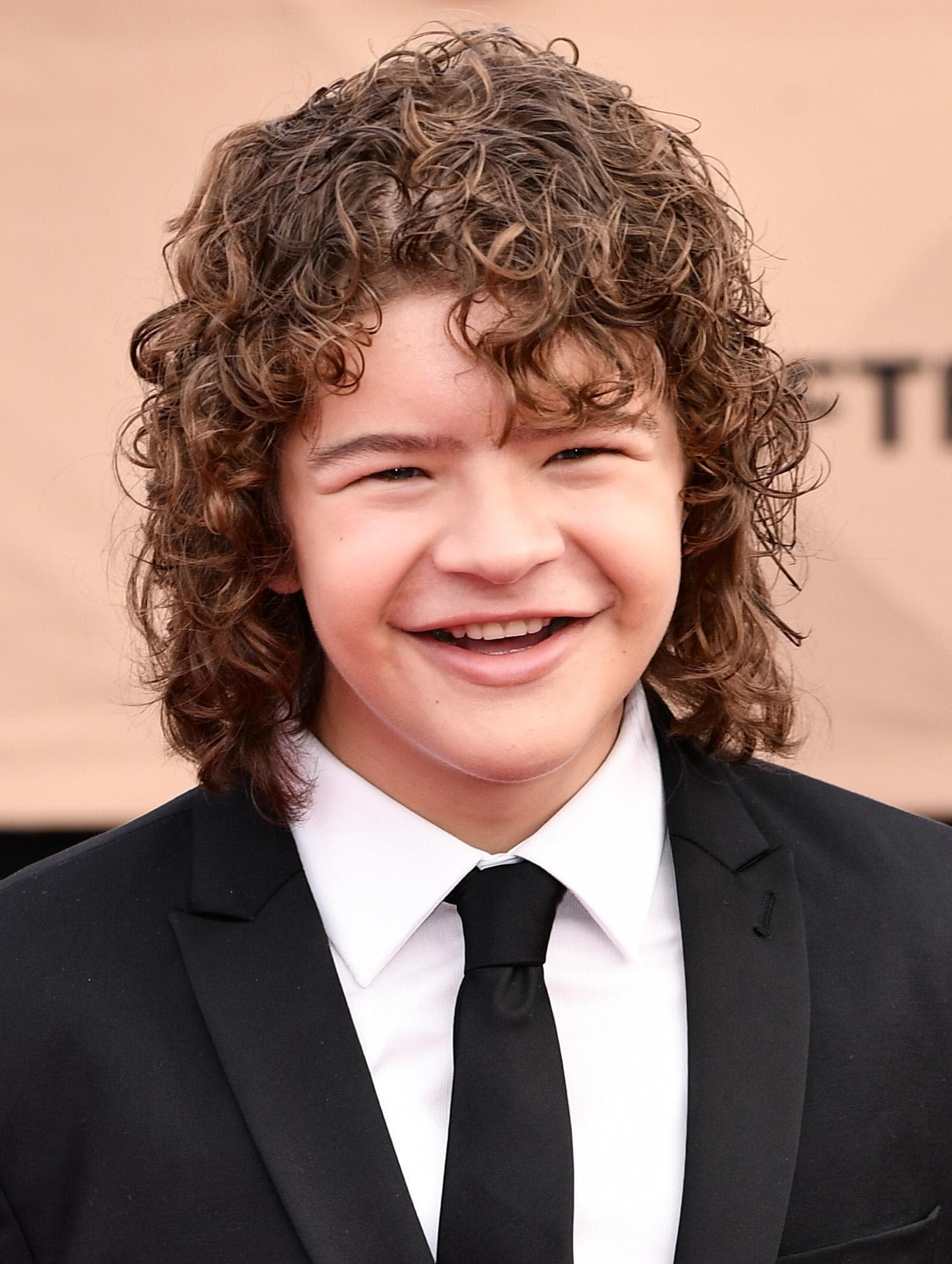 Gaten Matarazzo avec une coupe shaggy bouclée pour garçon