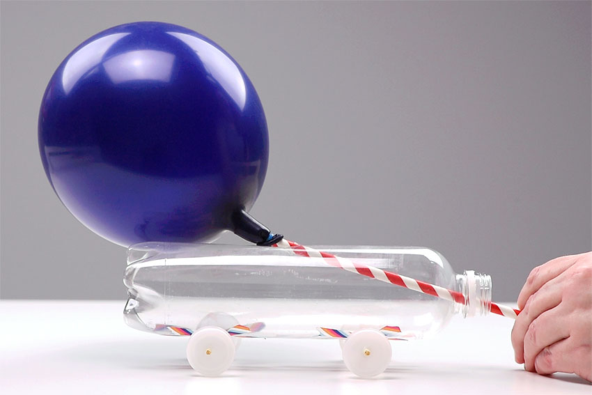 Écran d'activités gratuites pour les enfants - fabriquez une voiture propulsée par un ballon à partir d'une bouteille d'eau et d'une paille - une voiture propulsée par un ballon faite maison sur une table de One Little Project