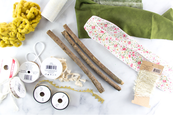 Fournitures nécessaires : ruban, bâtons et tissu pour faire une tenture murale