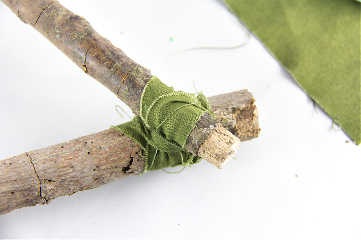 Étape 2 - Tenture murale Dream Catcher - Bandes de tissu vert attachées autour de deux bâtons.