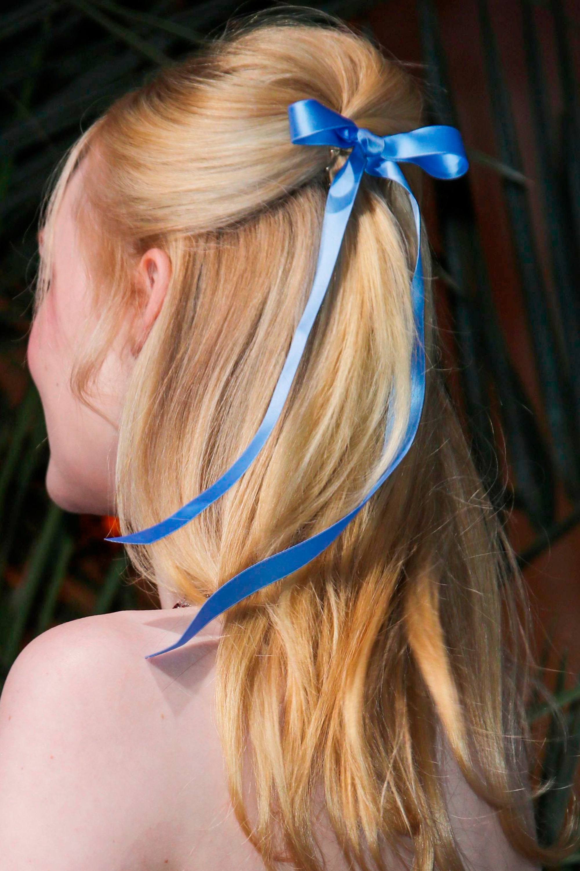 Elle Fanning avec une coiffure semi-collectée avec crêpe sur le côté
