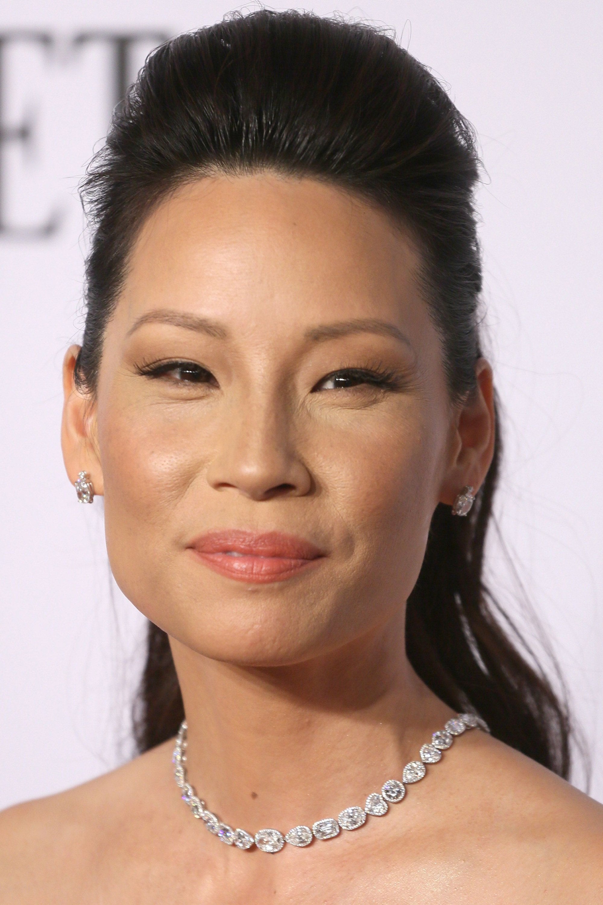 Lucy Liu avec demi-queue de cheval en crêpe, crêpe haut et cheveux semi-recueillis