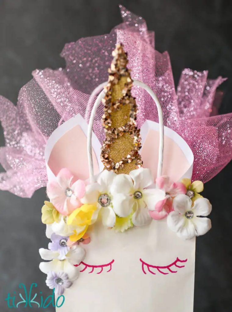Sac de fête licorne de Tikkido - sac de fête licorne artisanal présenté avec un outil coloré et pailleté et une corne de licorne