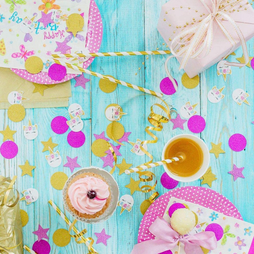 confettis de licorne montrés d'en haut sur une table saupoudrée pour une fête de licorne