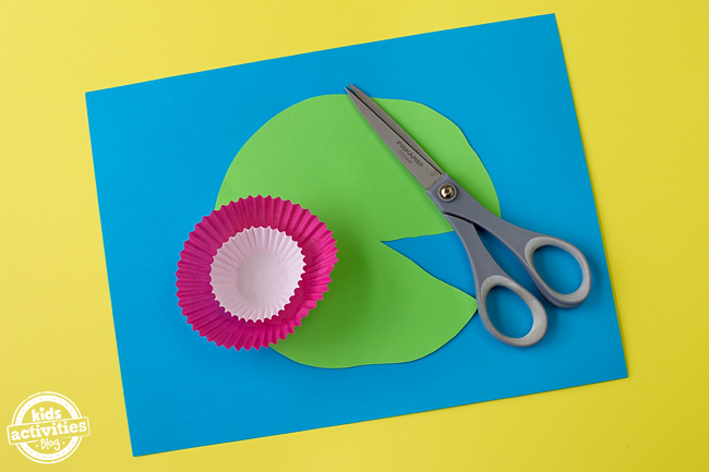 Cupcake Liner Frog Craft - Fabriquez votre nénuphar en découpant un triangle dans votre papier de construction vert.
