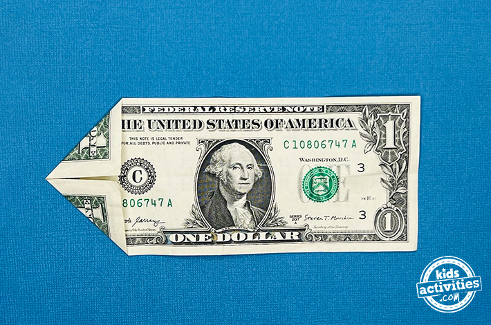 Poisson origami en forme de billet d'un dollar - étape 2 - Pliez les deux coins gauches vers l'avant pour rejoindre le pli central créé à l'étape précédente.