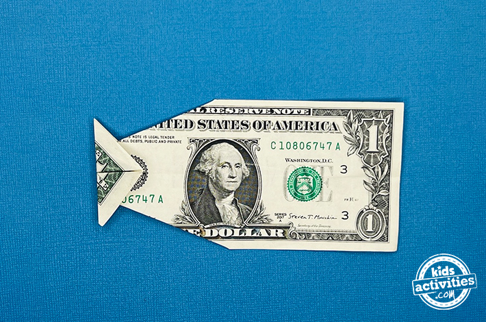 Poisson origami en forme de billet d'un dollar - étape 6 - Pliez les extrémités du billet vers l'intérieur pour créer une forme triangulaire.